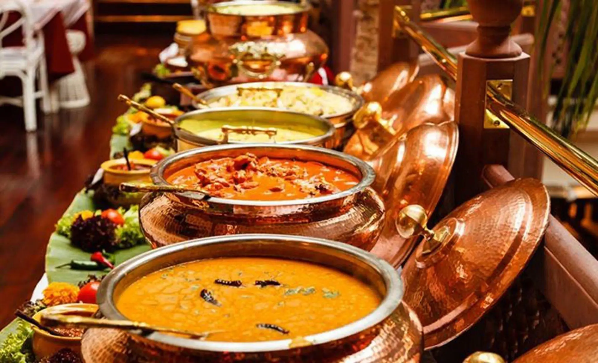 Indian buffet dishes served in copper vessels for a Diwali catering setup.